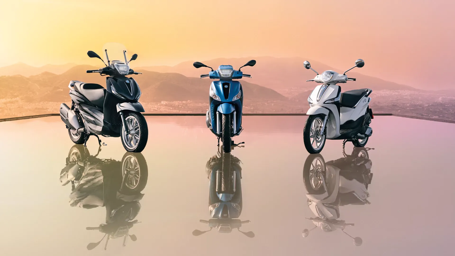 Drei Piaggio Promo Motorräder stehen vor einer Skyline beim Sonnenuntergang auf einer Glasfläche.
