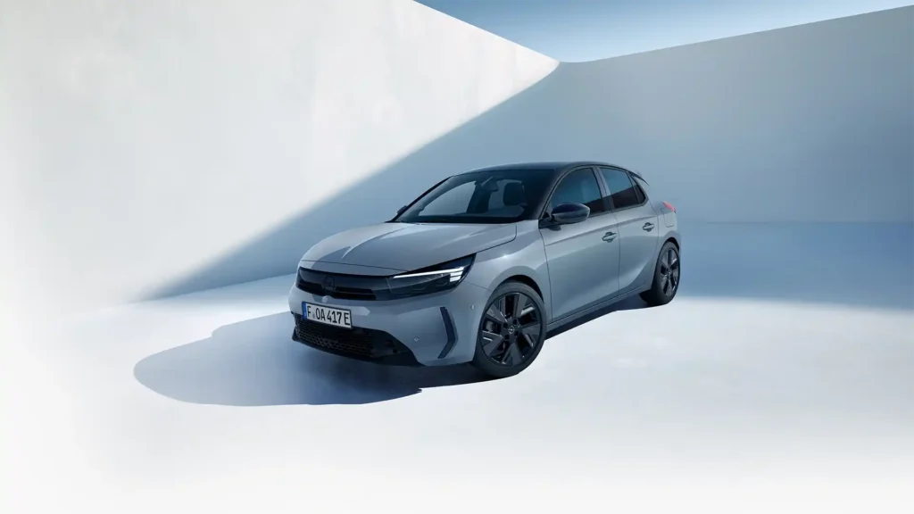 Ein Opel Corsa Electric steht vor zwei weißen Wänden.